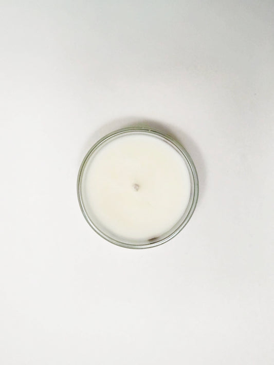 White candle in a glass jar on a white background