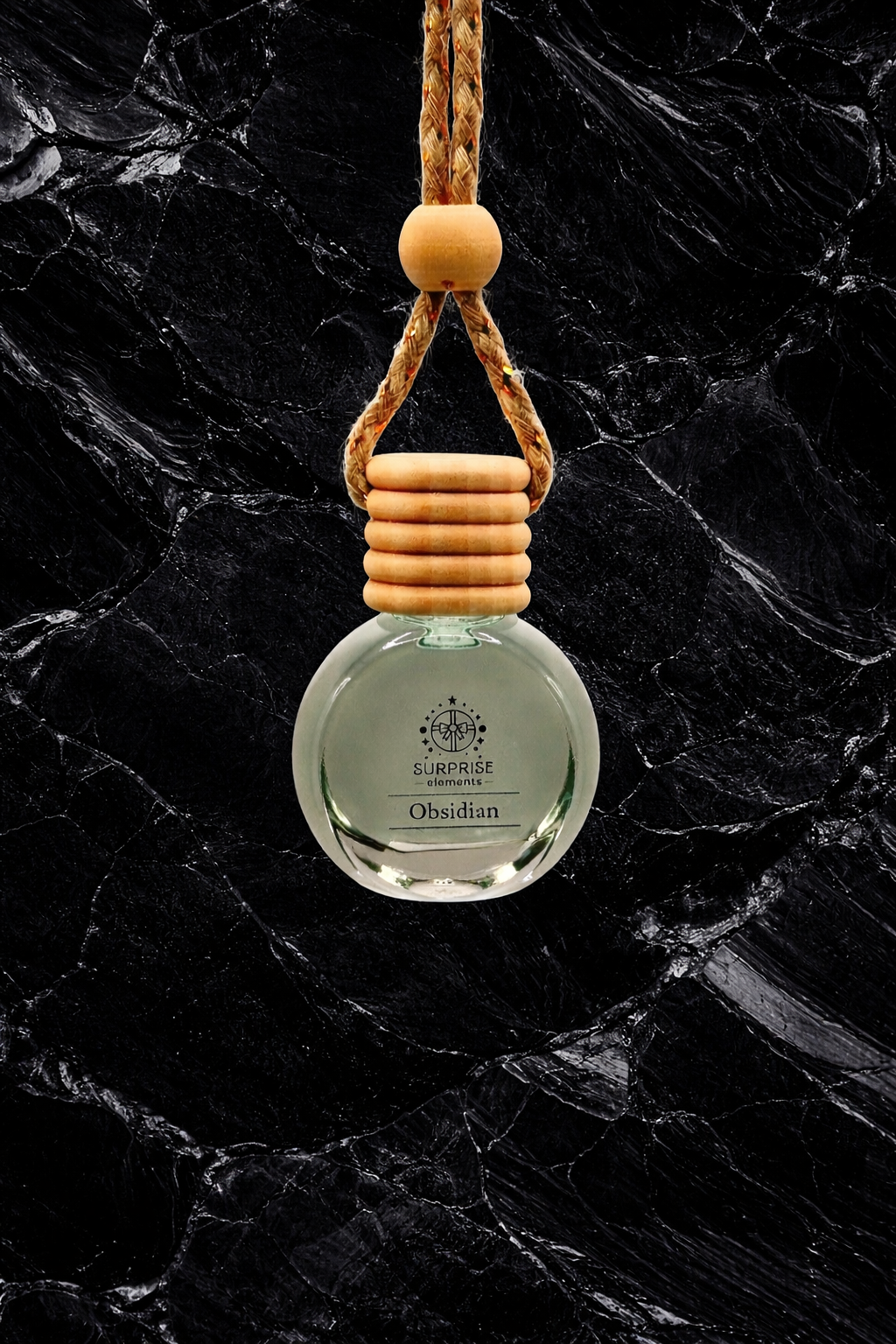 car fragrance obsidian clear bottle with wooden holder on a black marble background