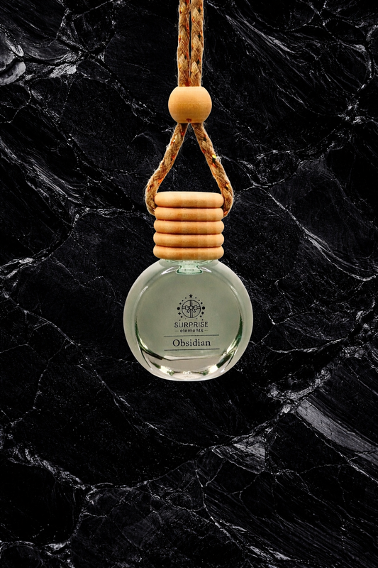 car fragrance obsidian clear bottle with wooden holder on a black marble background