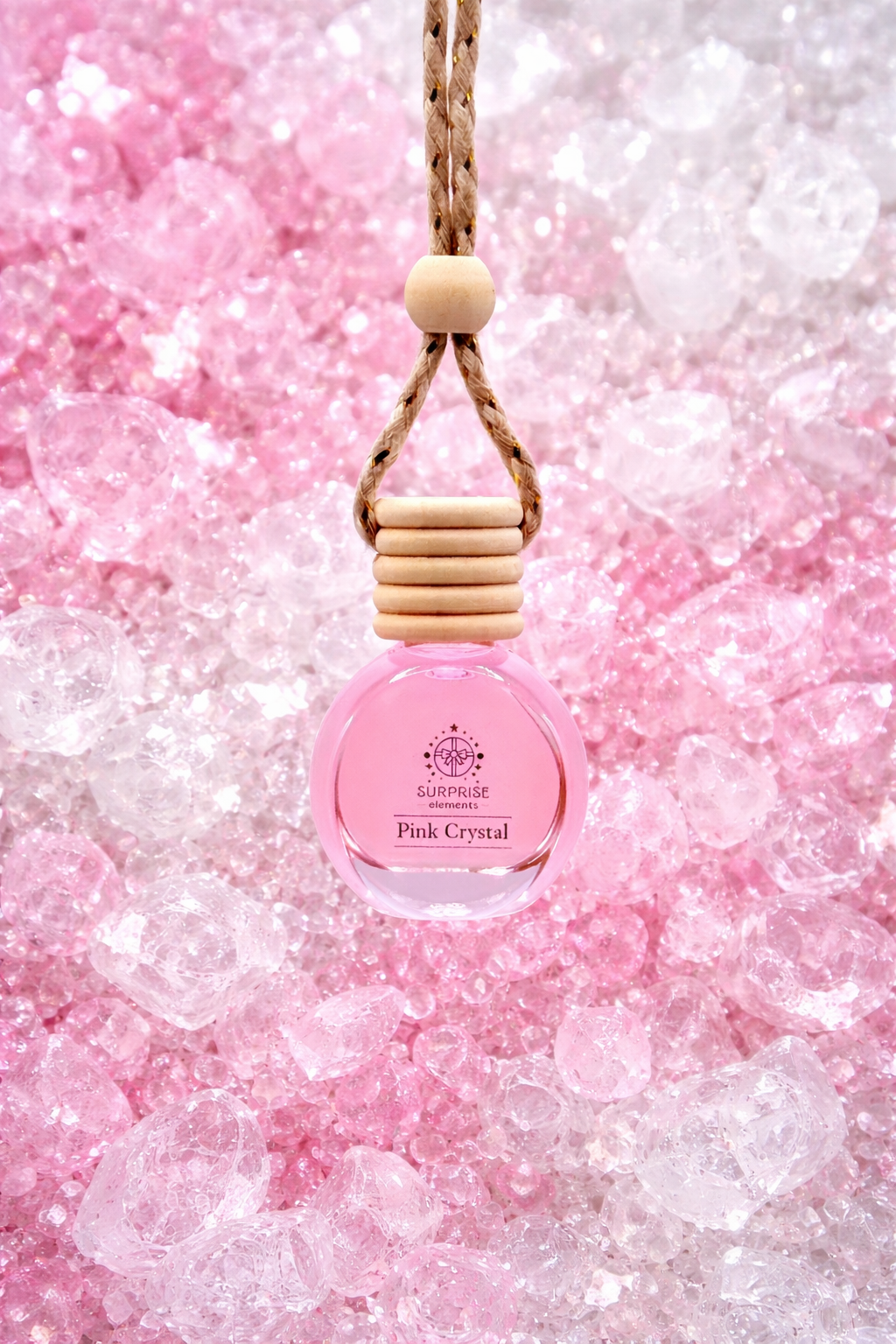 Pink crystal car fragrance bottle with wooden cap on a pink glittery background surprise elements logo on the bottle  