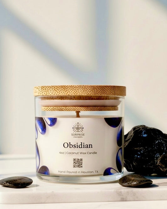 Obsidian candle with decorative label on a light background 4oz clear with bamboo lid candle jar coconut wax hand-poured in Houston Texas 