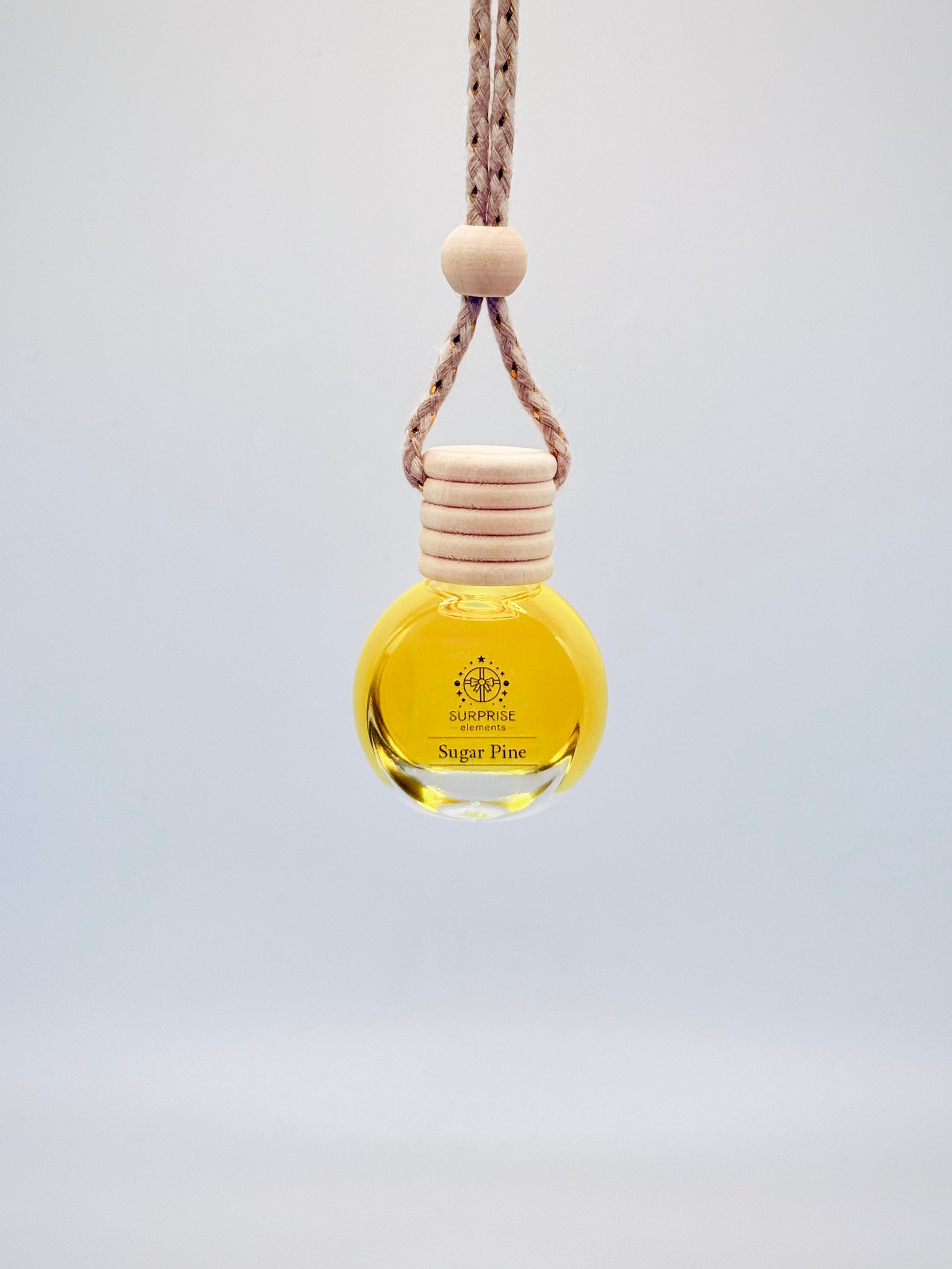 sugar pine car fragrance bottle with wooden cap and rope on a light gray background