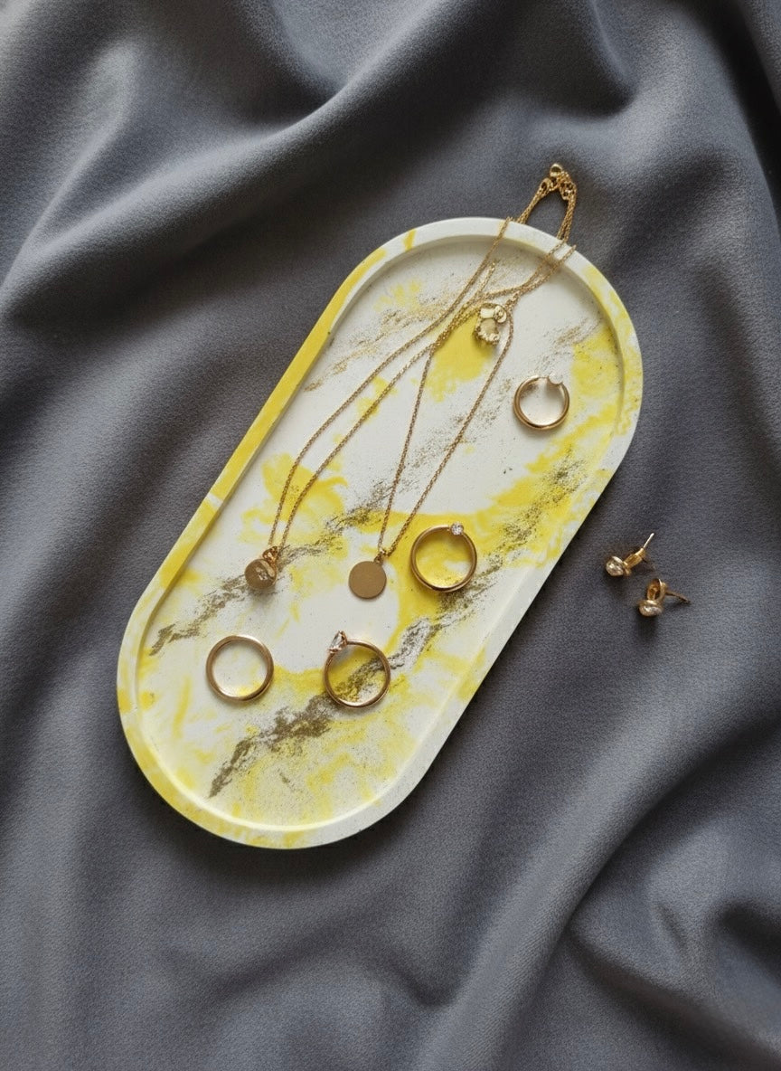 Jewelry set on a yellow and white marbled tray on gray fabric