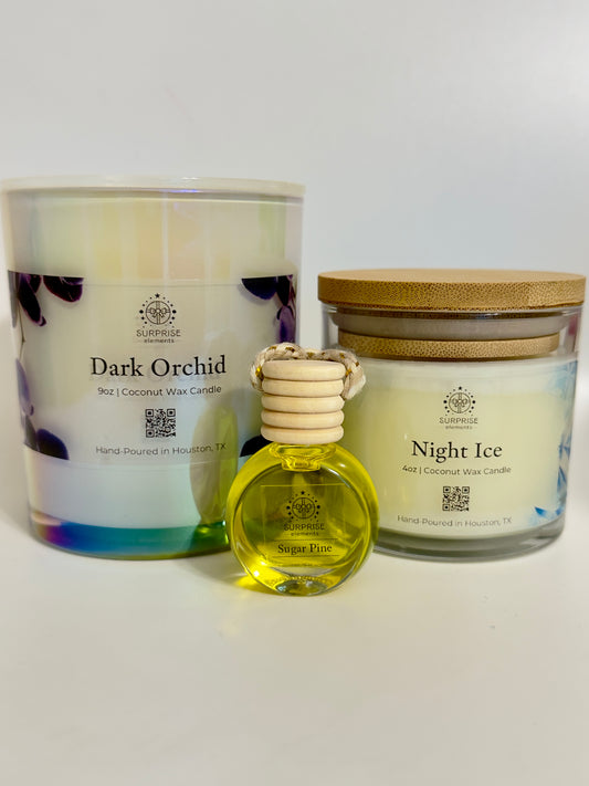 Two candles and a small bottle of car fragrance on a white background