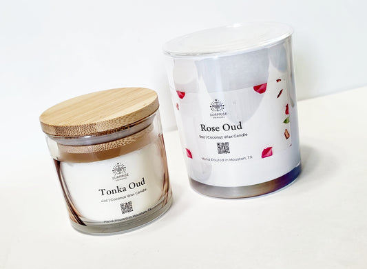 Two candles, tonka oud clear glass jar with bamboo lid 4oz coconut wax candle hand-poured in Houston Texas and rose oud pearl white candle jar 9oz coconut wax candle hand-poured in Houston Texas written on the label , with visible branding on a white background.