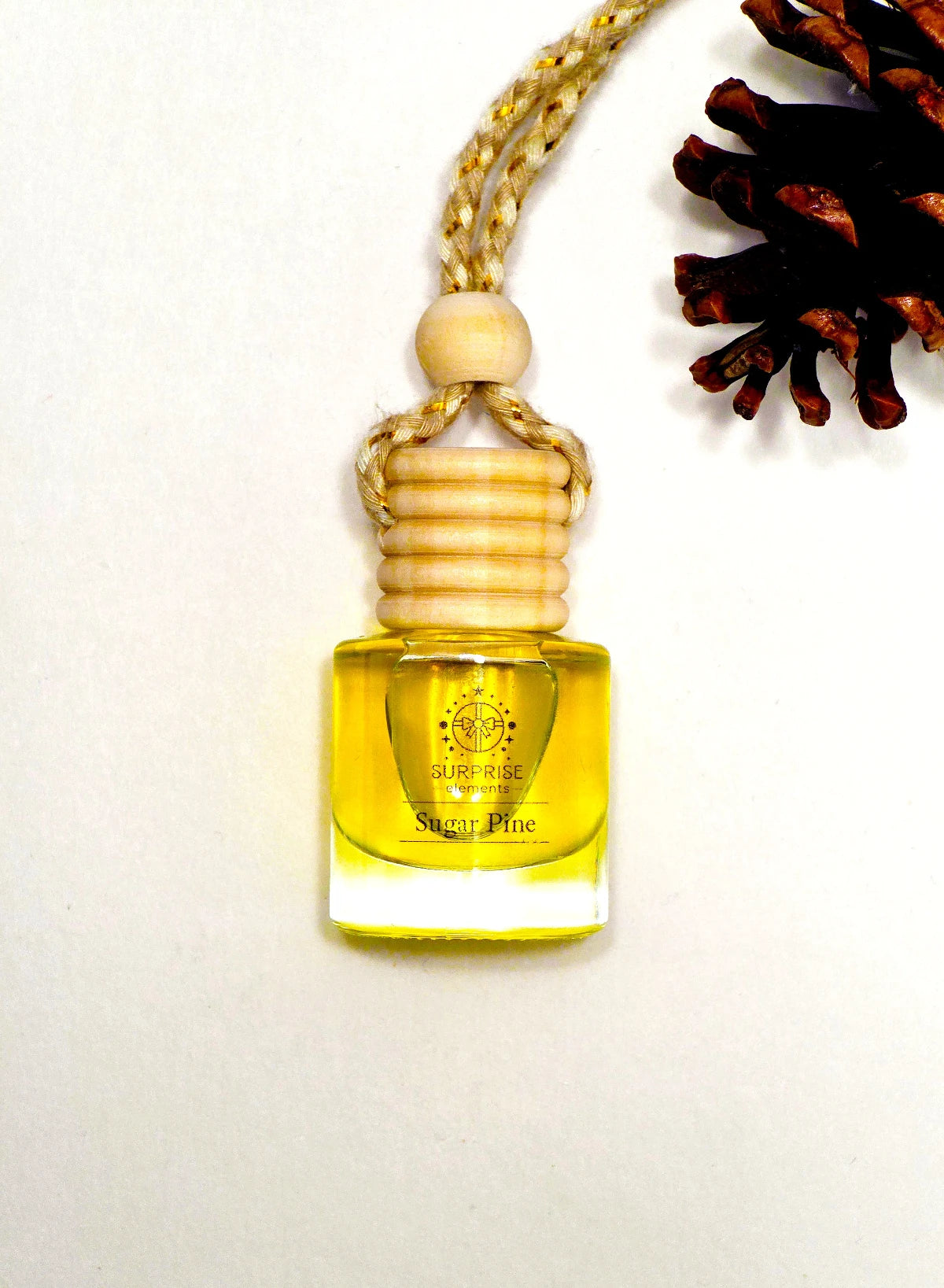 Small glass bottle with car fragrance  yellow liquid on a white background surprise elements logo on it 