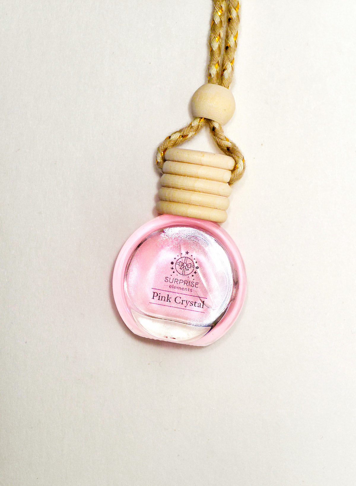 Pink crystal bottle with wooden cap on a white background